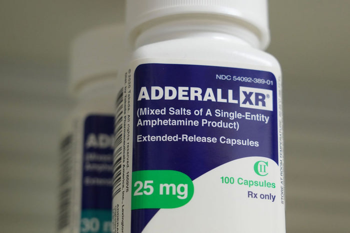 Prescription Adderall XR bottle representing a patented big pharma stimulant drug contrasted with non patentable compounds like methylene blue