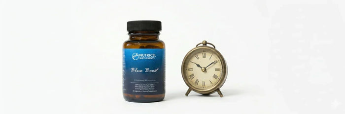 Nutricel Blue Boost supplement bottle next to a vintage brass clock on a clean white background, representing premium cognitive health and longevity.