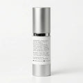 A cylindrical cosmetic pump bottle with a metallic silver cap and a white label showing product ingredients and directions, photographed on a clean white background.